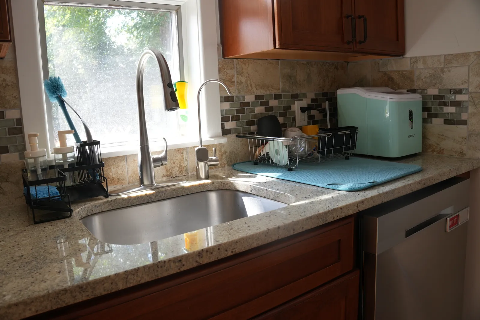 A spotless kitchen counter with a gleaming sink and clear draining board