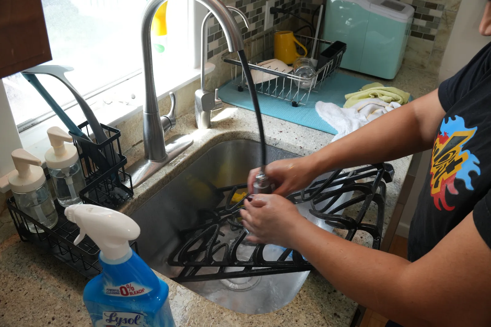 Scrubbing a stove grate clean in a kitchen sink